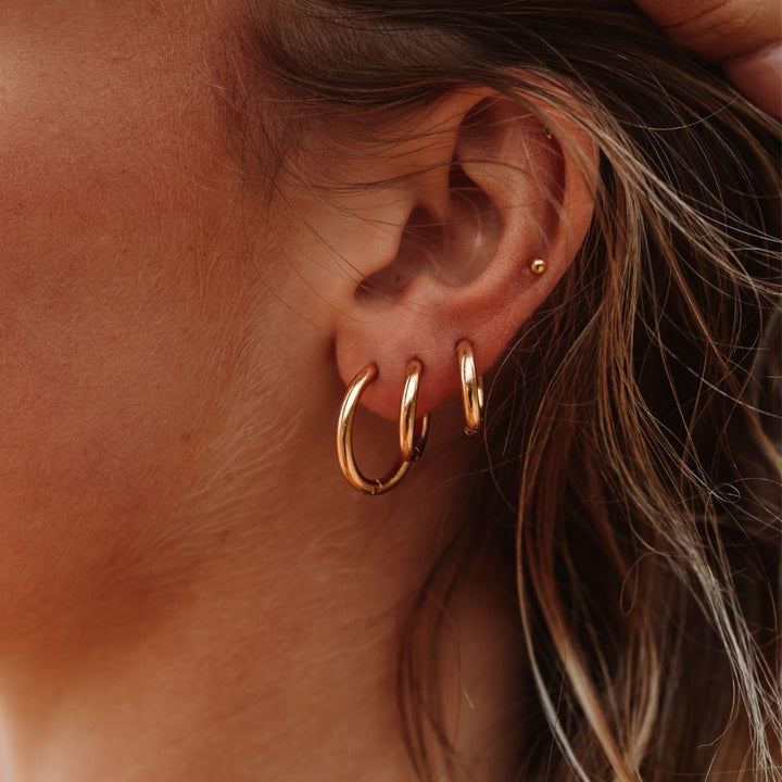 A pair of classic gold hoop earrings, perfect for everyday wear, shown on a white background, Celeste style.