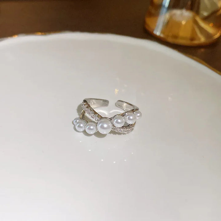 Close-up of an adjustable vintage pearl and zirconia ring, a timeless fashion accessory for women.