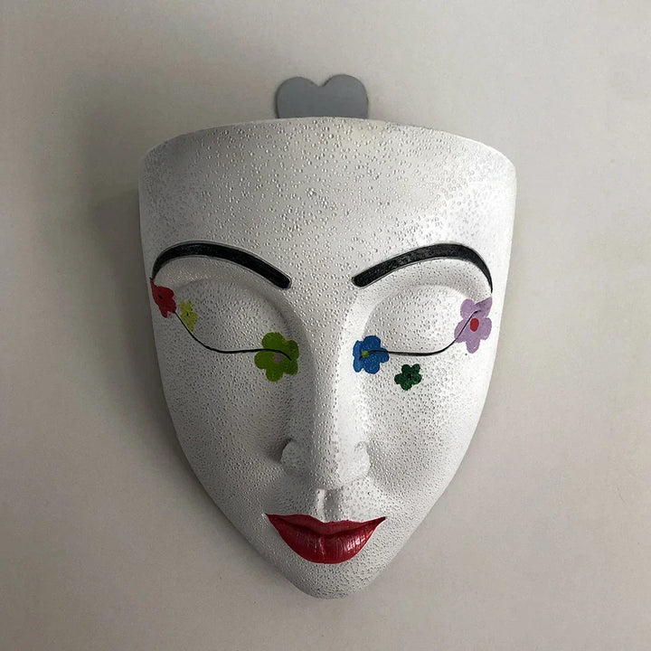 Sculptural human face hanging planter, unique resin pot & wall decor. Artistic home accent for vibrant indoor plants.