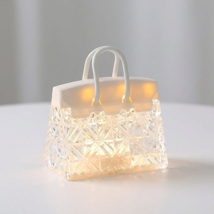 Decorative LED table lamp shaped like a handbag, providing ambient lighting for a nightstand