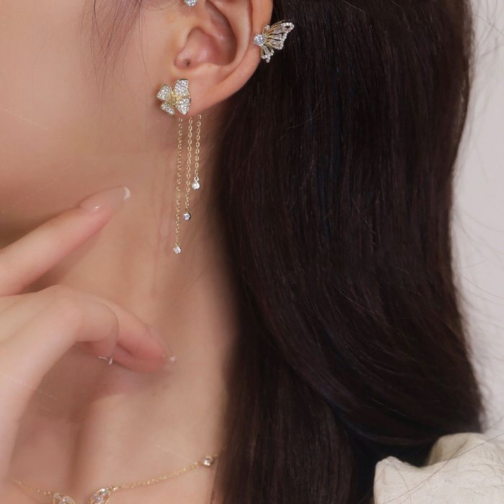 Model wearing elegant silver butterfly drop earrings, showcasing fashion accessory