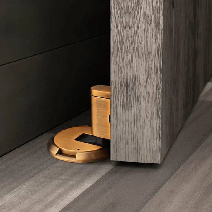 Bronze magnetic door holder prevents wall damage, keeps doors open silently with strong adhesive.