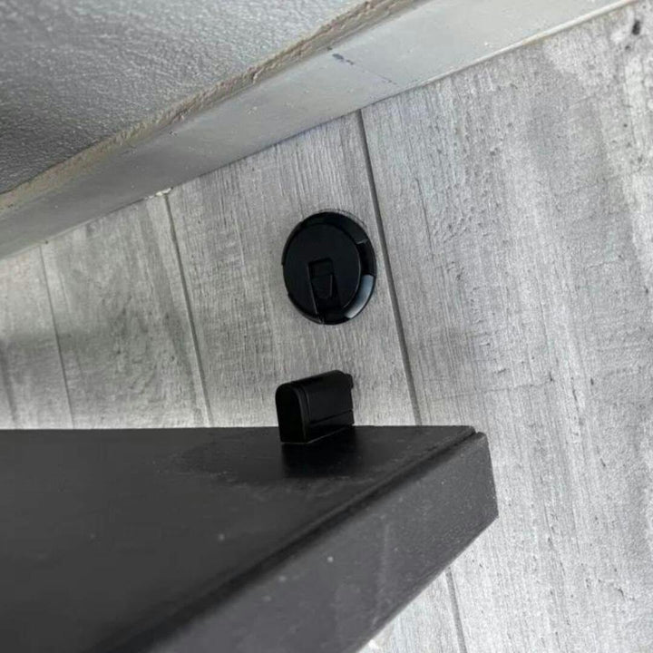 No-drill adhesive magnetic door stop in black, securely holds doors open, preventing slams and wall damage.