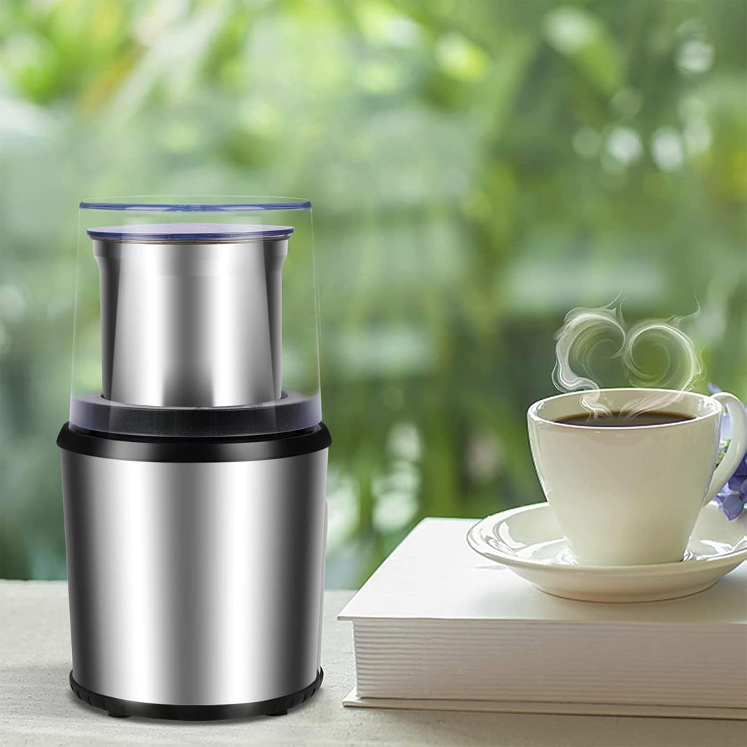 Close-up of BrewMate electric coffee grinder with clear lid, showing ground coffee beans, home kitchen tool