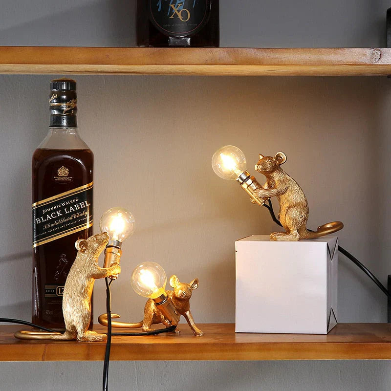 Close-up of a playful gold resin mouse LED table lamp, highlighting its intricate design and warm light.
