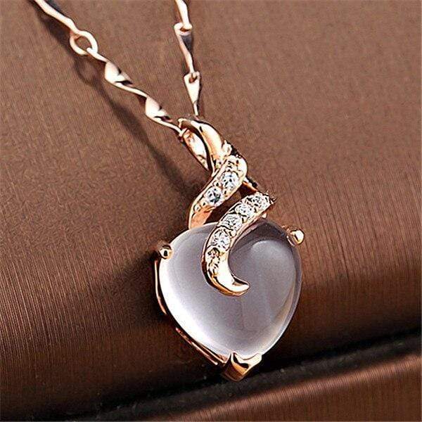 Close-up of women's silver opal heart necklace, highlighting the iridescent opal and Calista design.