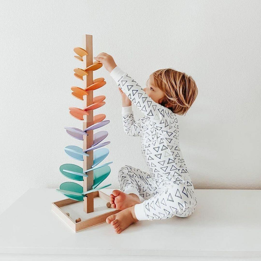 Toddler's interactive wooden rainbow sound tree, fostering early development, sensory play & motor skills with marbles.