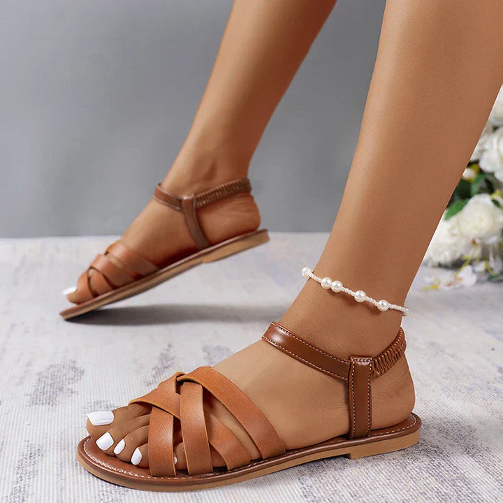 Brown Roman style women's sandals, comfortable and flat, with a durable non-slip sole for summer adventures.