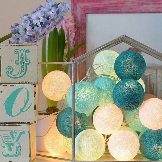 Long strand of decorative cotton ball fairy lights, ideal for large party decoration & cozy lighting.