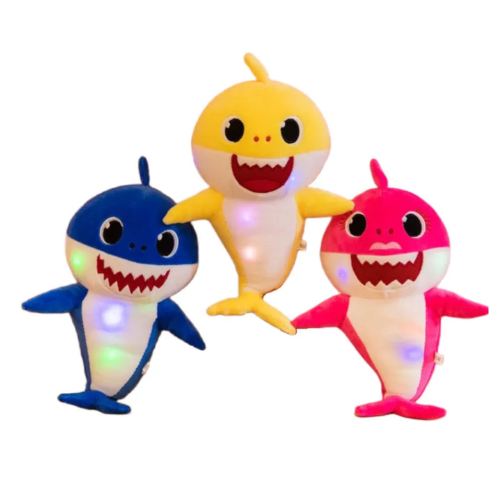 Cuddly singing shark plush toy for kids with colorful lights & music. A soft, interactive children's gift.