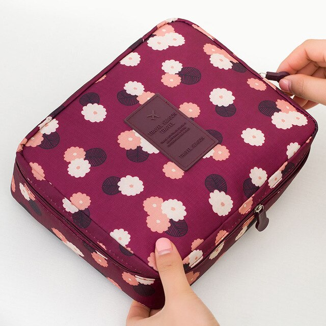Waterproof cosmetic travel bag, dark blue floral print, compact size.