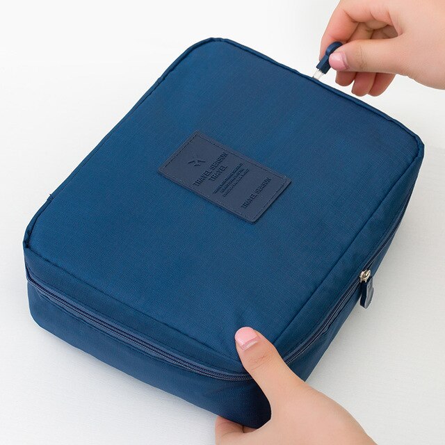Compact dark blue floral waterproof travel bag for makeup and toiletries.