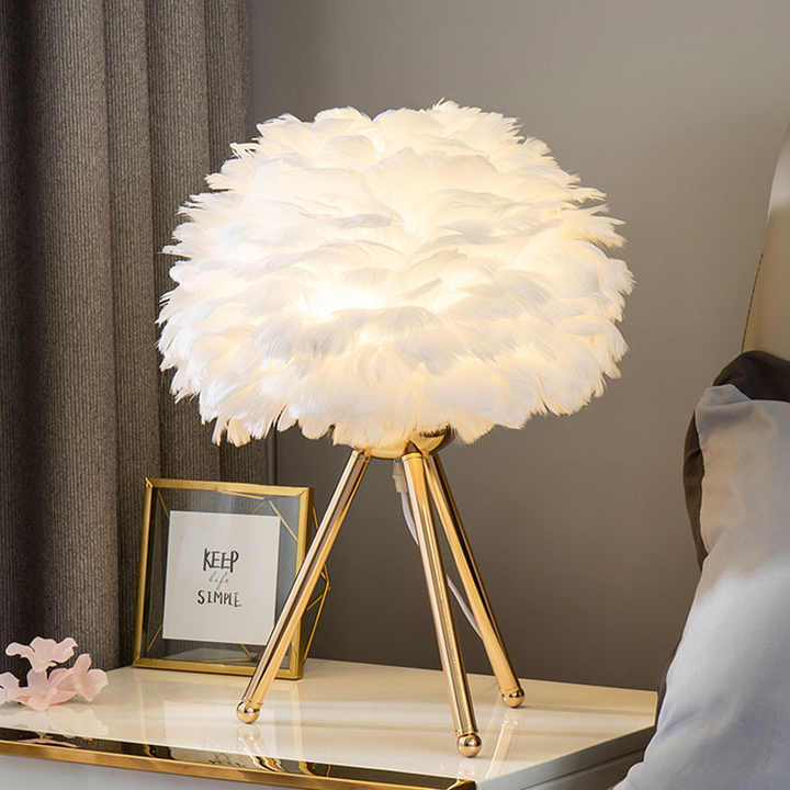Dimmable feather table lamp with elegant white plumes, perfect for luxurious bedroom or living room decor.