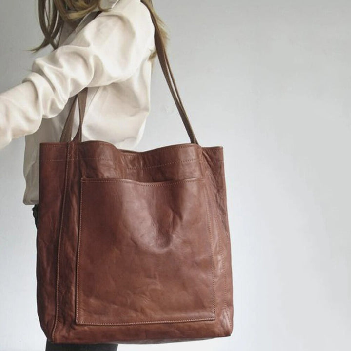 Durable leather shoulder bag for women. Elegant everyday handbag in black, light brown, or dark brown finishes.