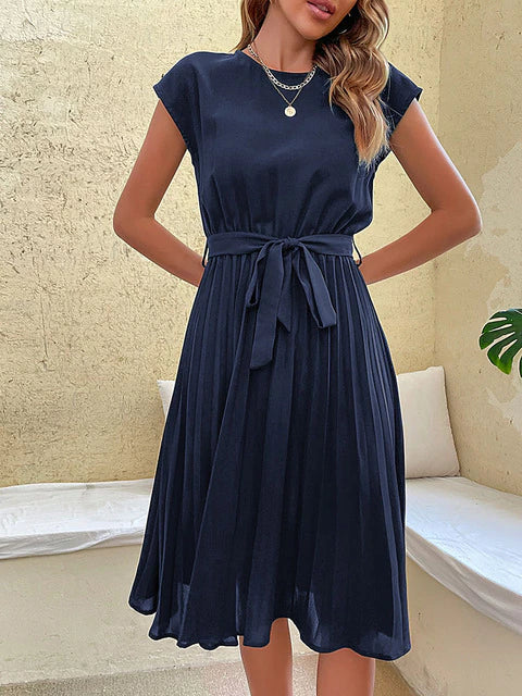 Woman modeling a trendy Felina pleated mini dress, ideal for summer vacation wear or a stylish day outfit.