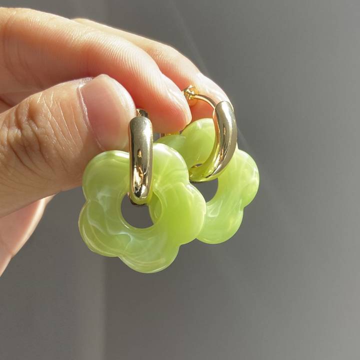 Close-up of women's gold plated flower drop earrings, showcasing intricate floral design.