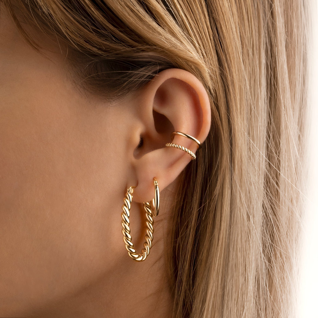 Stylish women's braided hoop earrings, featuring a unique woven design in sterling silver and gold.