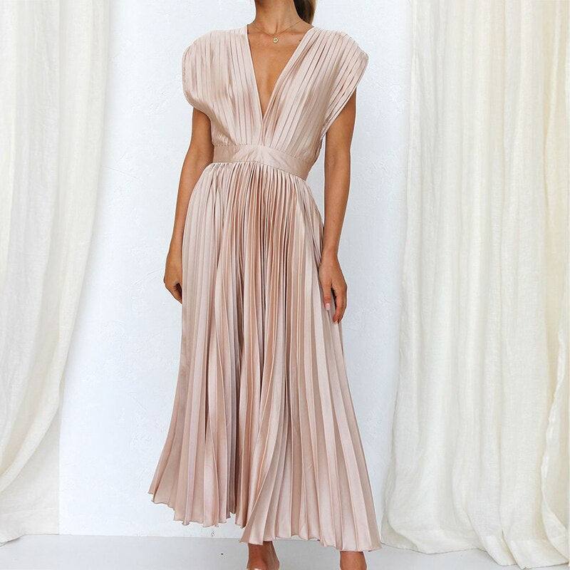 Close-up of the V-neckline and elegant pleats on a women's flowing maxi dress, showcasing the fabric.