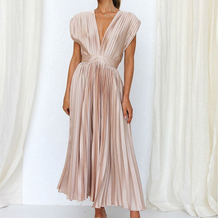 Close-up of the V-neckline and elegant pleats on a women's flowing maxi dress, showcasing the fabric.