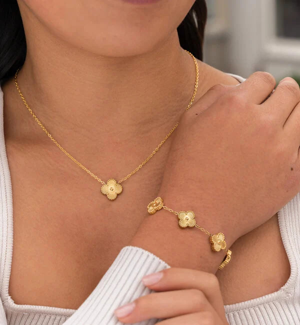 Stylish women's clover necklace and earrings set, showcasing the intricate detail of the lucky four-leaf design