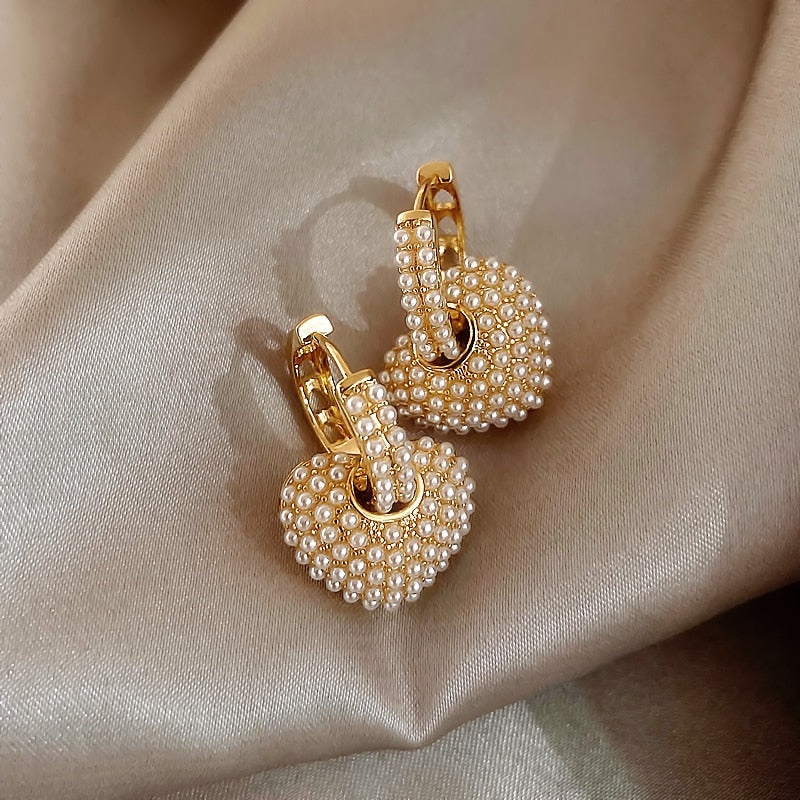 Close-up of stylish gold pearl drop earrings for women, showcasing intricate design and pearls.