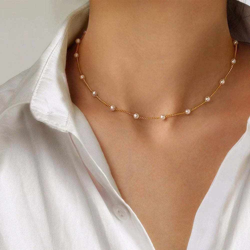 Elegant women's golden pearl necklace, Marilena design, featuring lustrous pearls and a timeless gold chain.