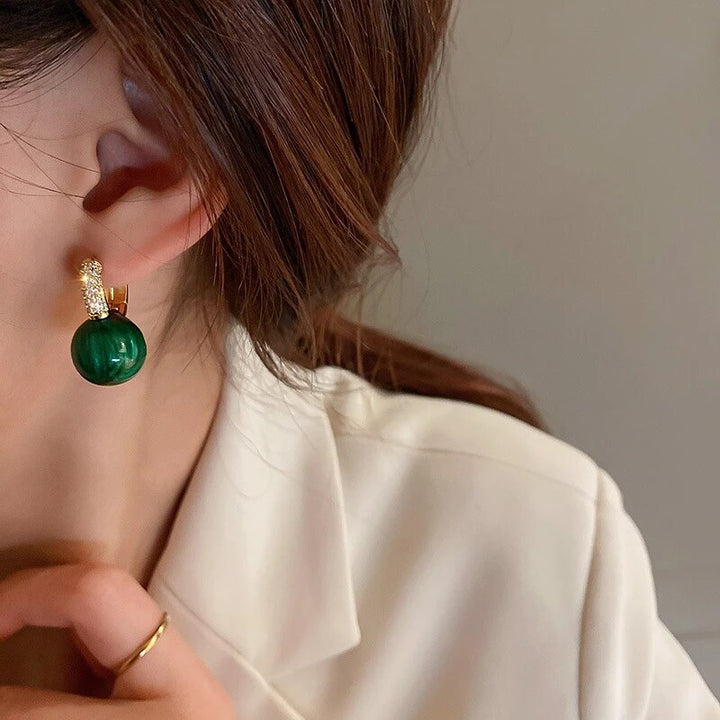 Close-up of elegant green pearl drop earrings, a beautiful pearl jewelry piece for women's fashion.