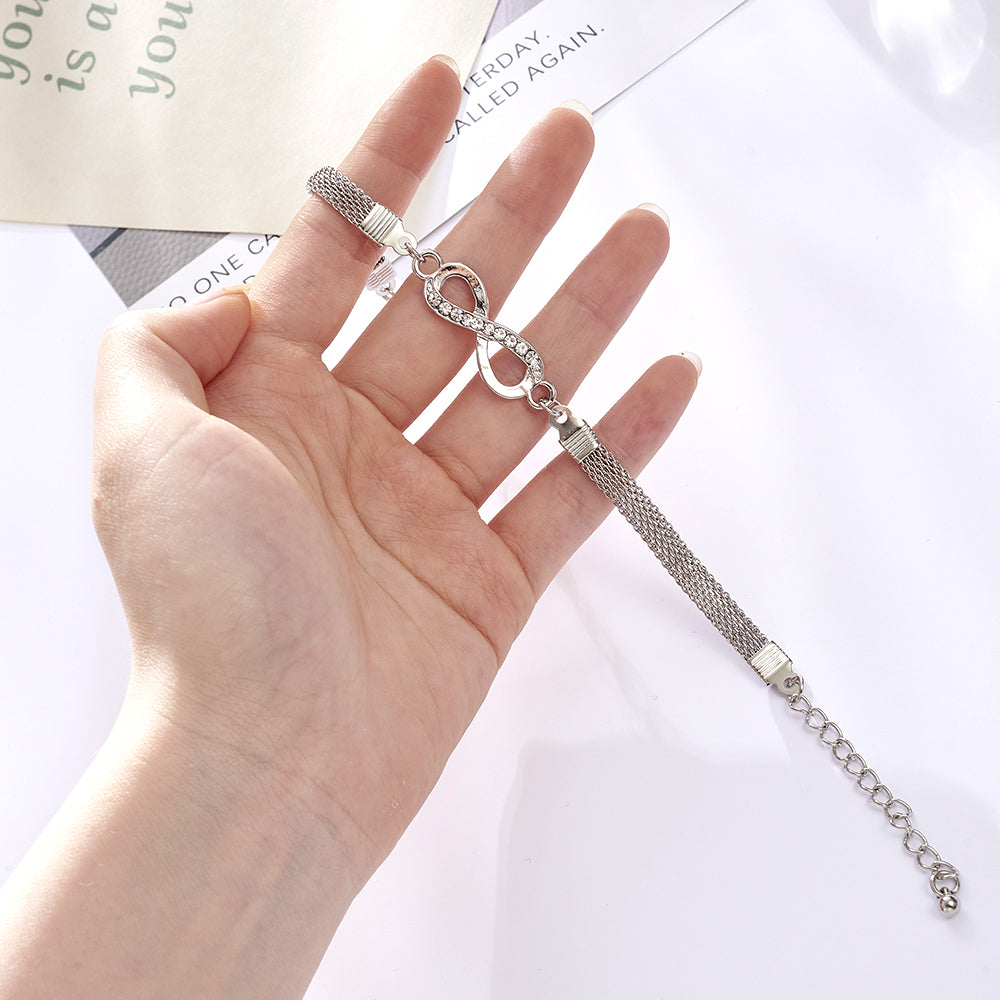 Woman wearing an elegant silver infinity bracelet, sparkling with crystals, a chic accessory for any occasion.