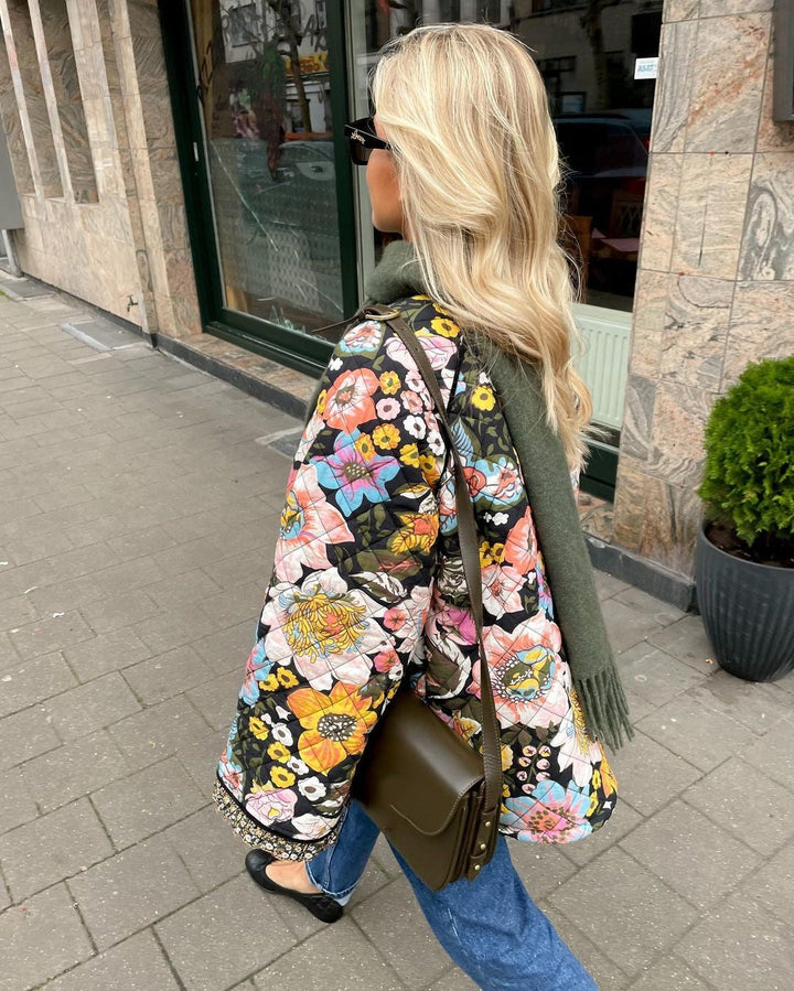 Stylish women's floral print padded coat. Comfortable, warm outerwear, ideal for trendy autumn and winter fashion.