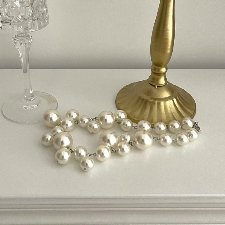 Close-up of a luxurious women's elegant pearl necklace featuring polished round simulated pearls.