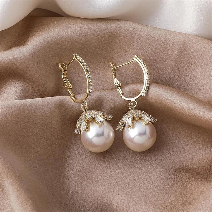 Minimalist women's pearl drop earrings; refined silver design offers elegant, timeless appeal.
