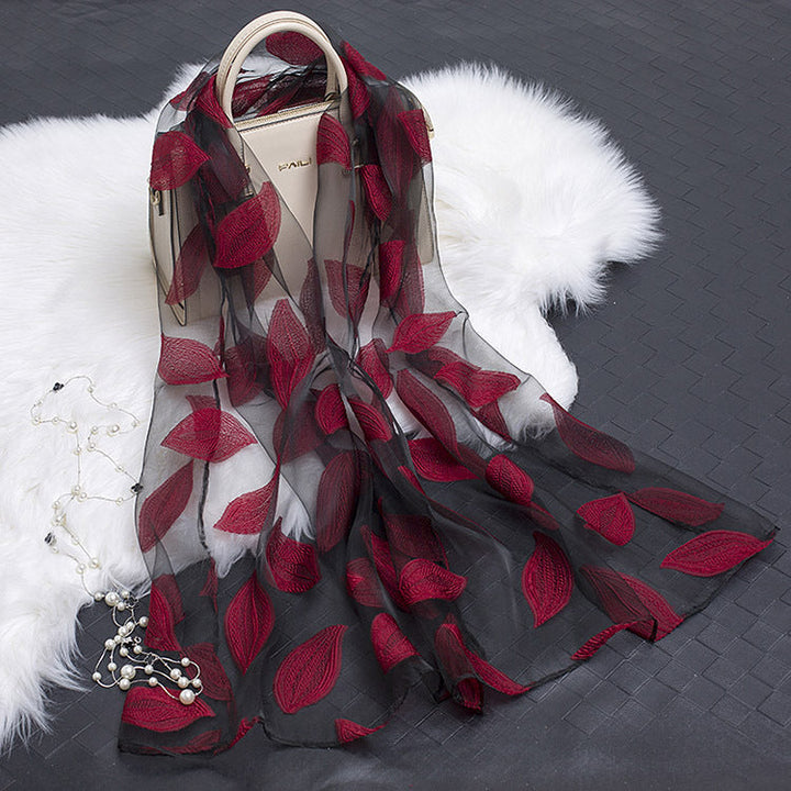 Luxurious silk scarf for women with delicate floral cut-out details.