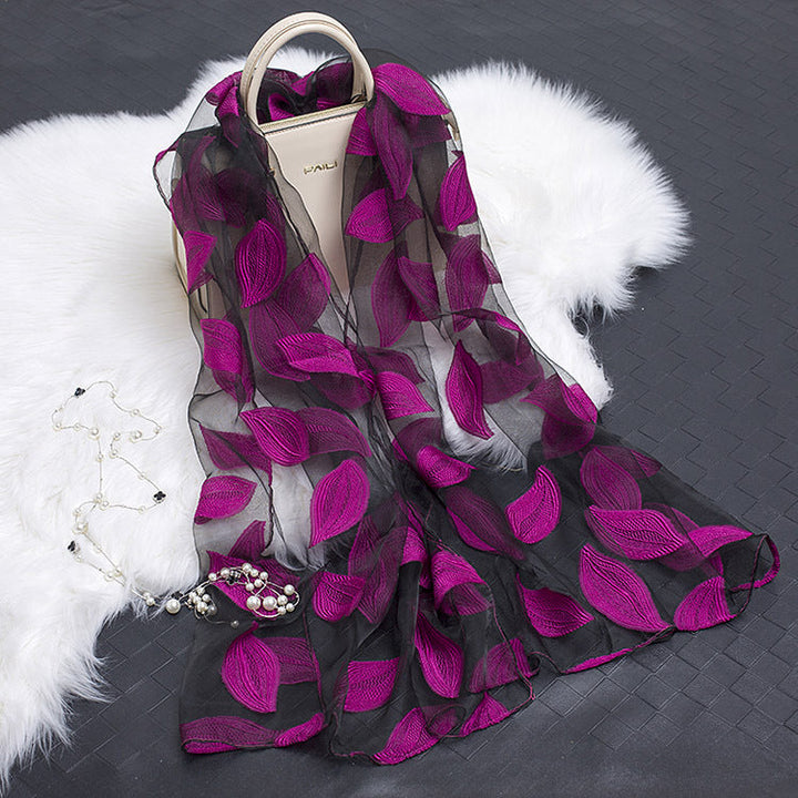 Lightweight women's silk scarf with intricate floral cut-outs, a stylish accessory.