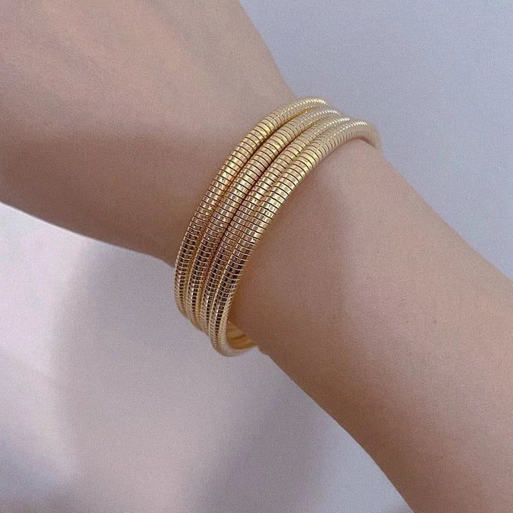 Elegant women's snake bracelet in gold or silver. Stylish fashion bangle, perfect statement jewelry for any outfit.