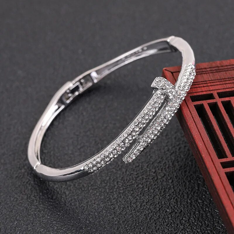 Close-up of a women's sparkling zircon cuff bracelet with unique elegant nail design, adjustable fit.