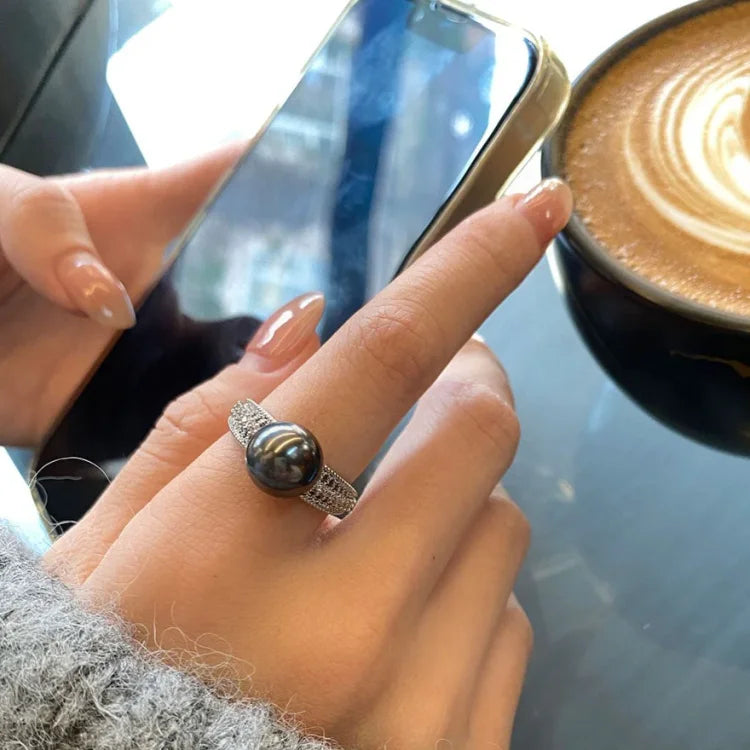 Close-up of a women's vintage openwork pearl ring in sterling silver, elegant and timeless jewelry.
