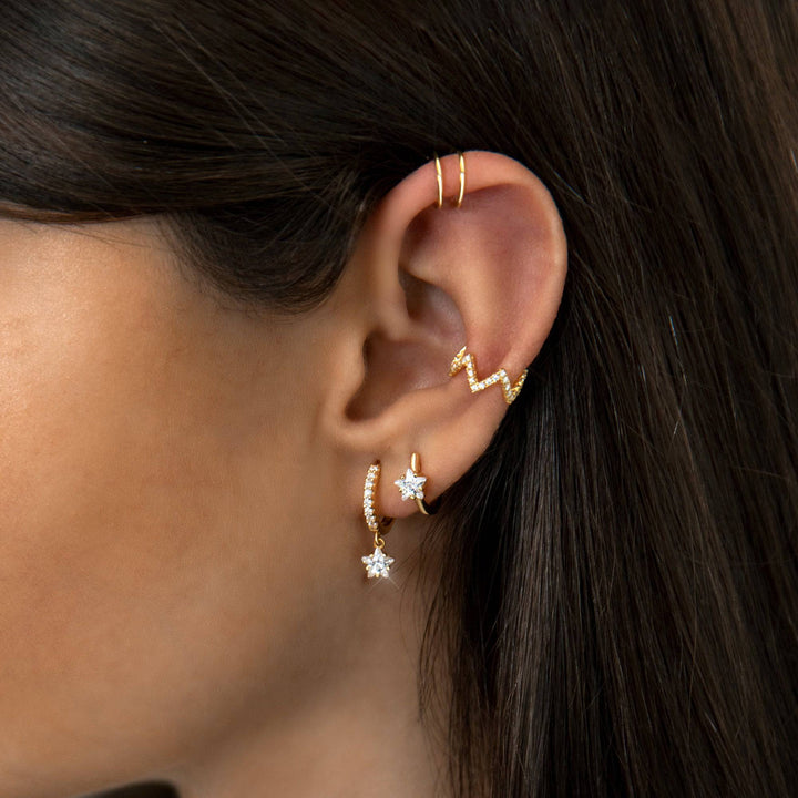 Detailed view of women's wide hoop earrings with intricate star zirconia, showcasing elegant craftsmanship.