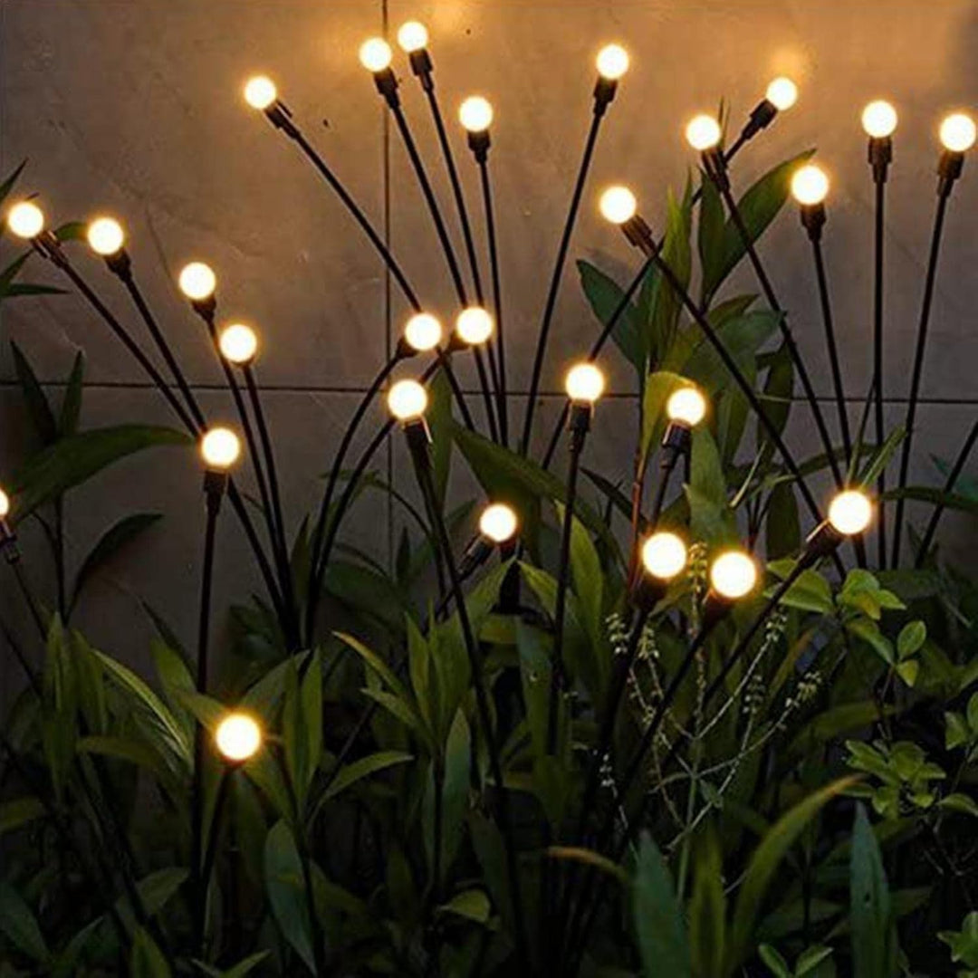 Magical floating solar firefly lights sway softly, illuminating gardens. Durable, solar-powered LED outdoor decor.