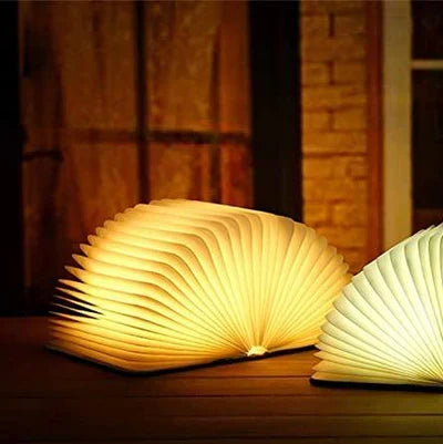 Modern StoryGlow folding LED book lamp with warm light, enhancing desk decor & mood.