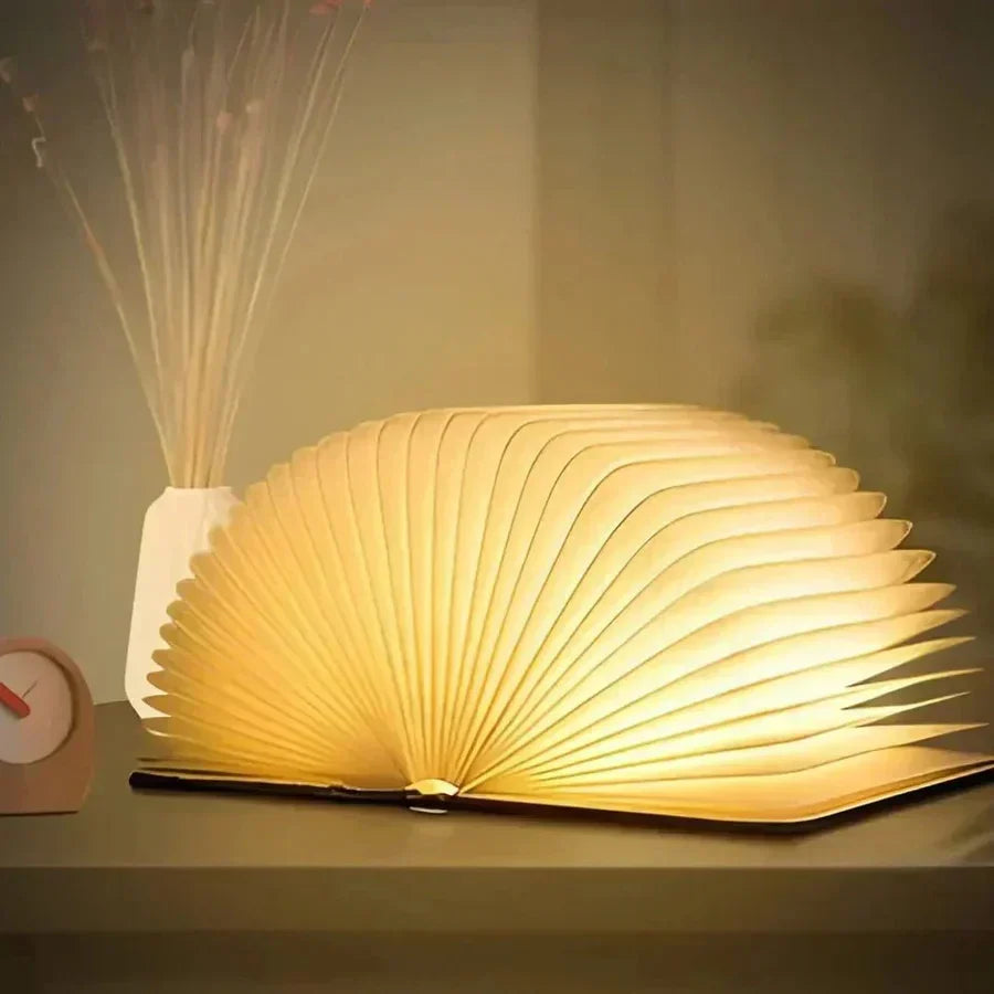 Compact folding LED book lamp, StoryGlow, provides warm, portable lighting for any space.