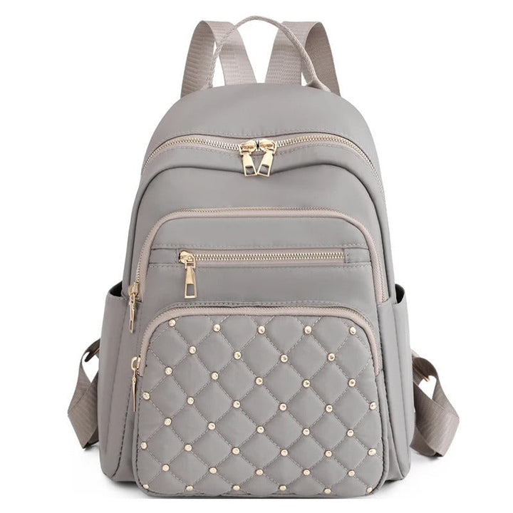 Close-up of the durable nylon fabric with water-resistant coating on women's backpack, khaki color.