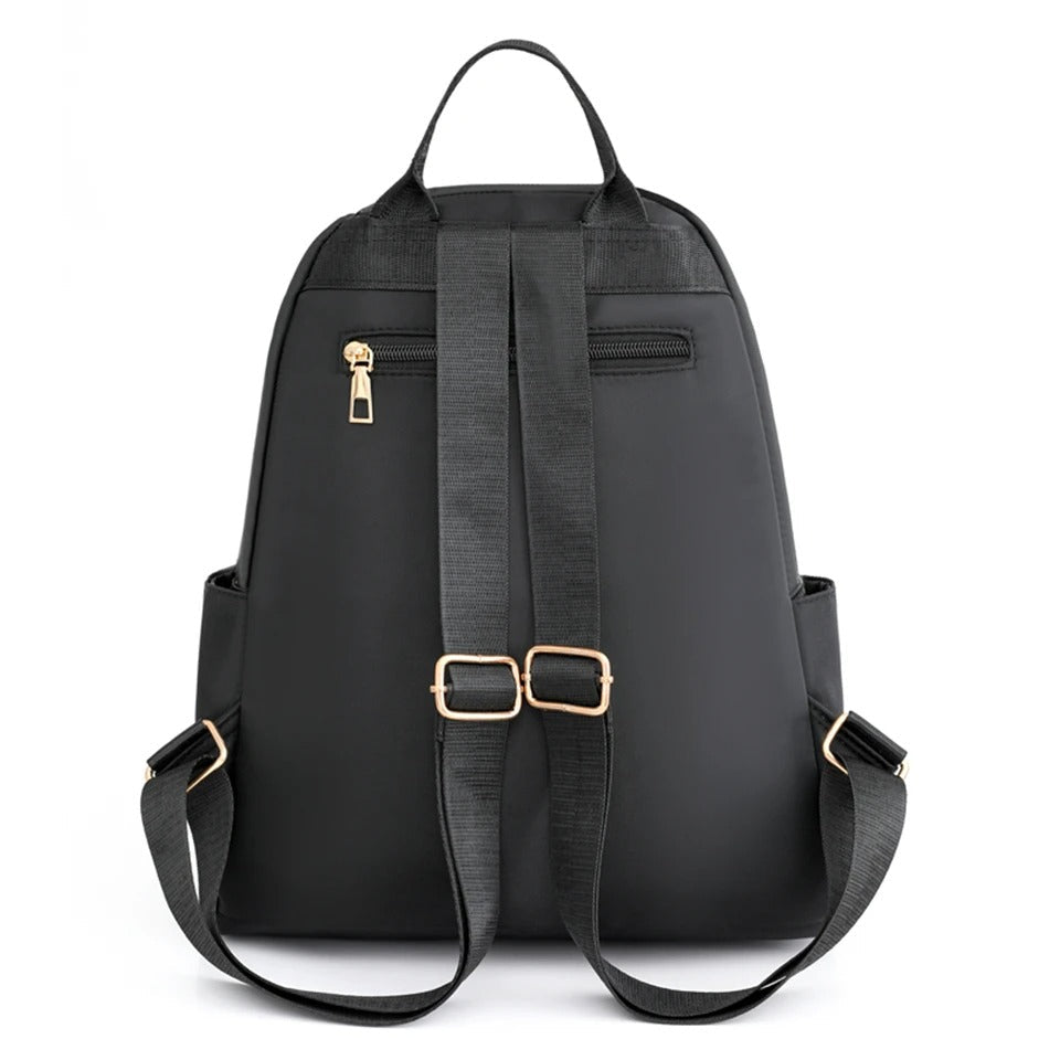 Detail of the zipper and adjustable straps on a black lightweight water-resistant women's backpack.