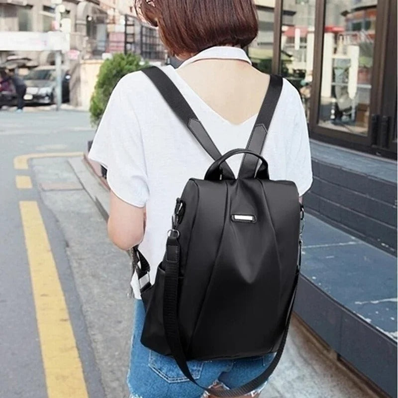 Ladies' practical water-resistant nylon backpack. Lightweight design, converts to crossbody or shoulder bag.