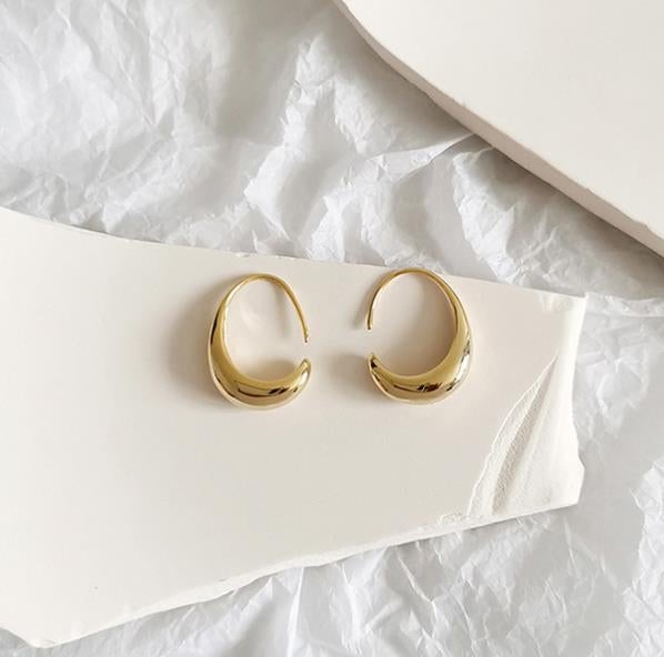 Women's elegant silver hoop earrings, a minimalist luxury jewelry piece. Perfect versatile fashion accessory.