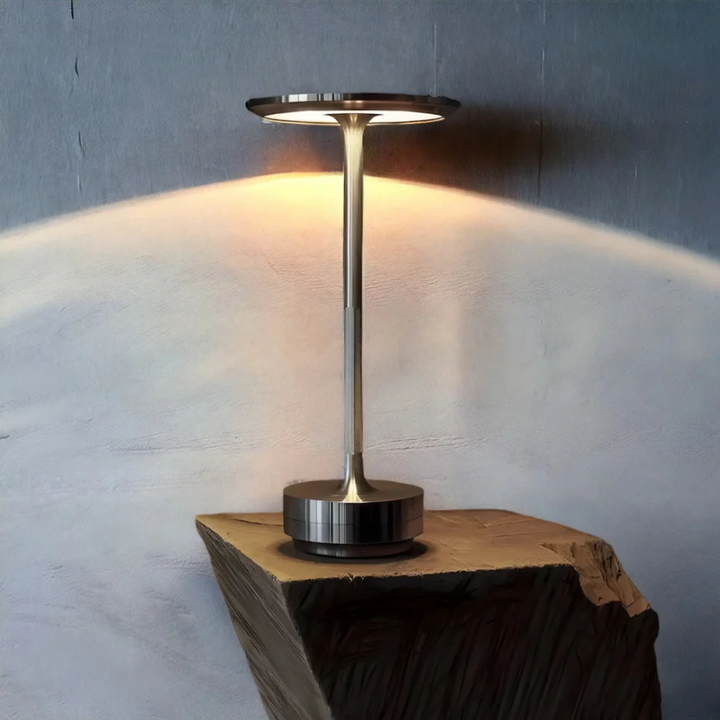 Sleek bedside lamp, wireless and rechargeable, providing soft ambient light for a modern living room.