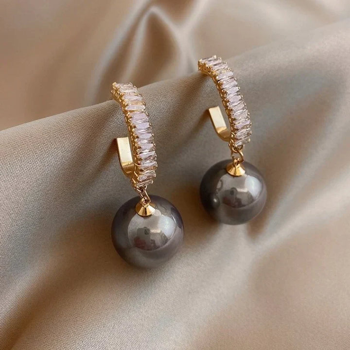 Luxury women's dangle earrings featuring elegant pearls and sparkling zirconia, perfect for a chic, classic look.