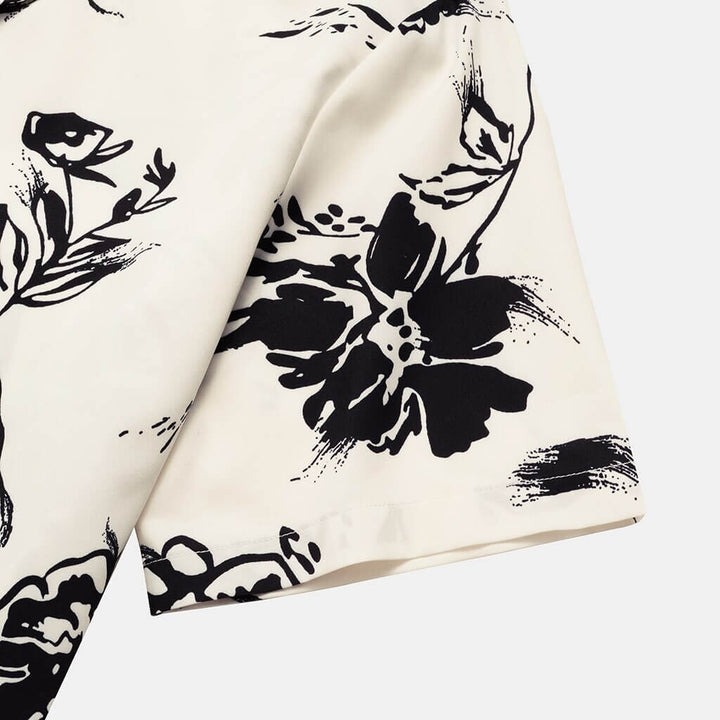 Styled men's tropical print shirt with sunglasses, ready for a beach vacation or casual summer event.