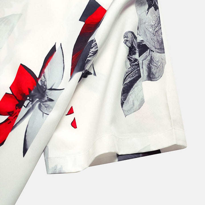 Man wearing a stylish tropical print short sleeve button-up shirt, ideal for beachwear and summer outings.