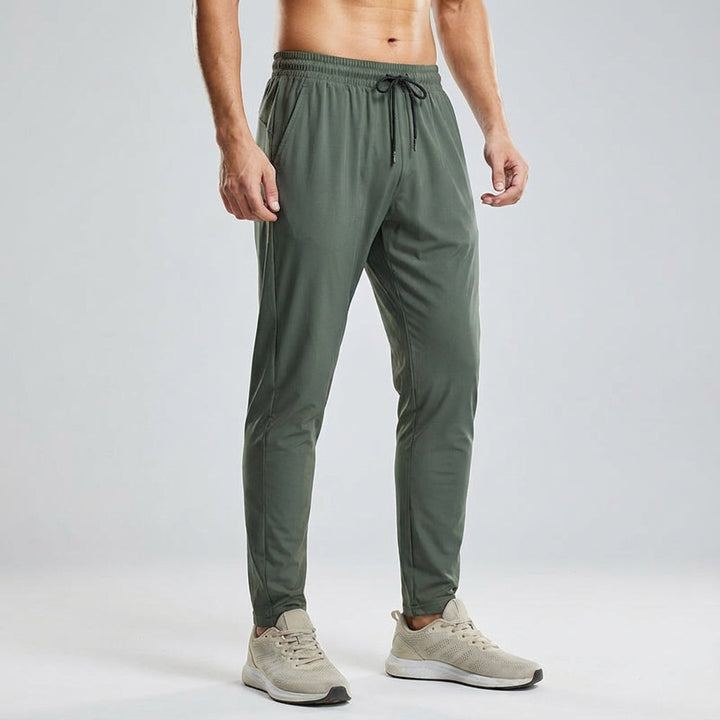 Stack of Vince men's training joggers in black, grey, and navy, highlighting versatile casual pants.