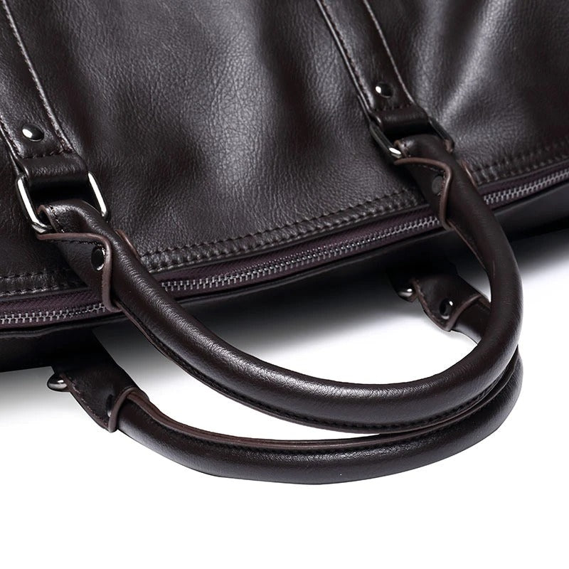 Men's leather travel bag in black, handheld by a stylish man, emphasizing its carry-on functionality